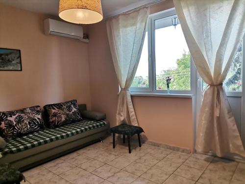 a living room with a couch and a window at Guest House 51 in Kranevo