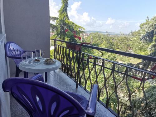 a balcony with two chairs and a table with wine glasses at Guest House 51 in Kranevo