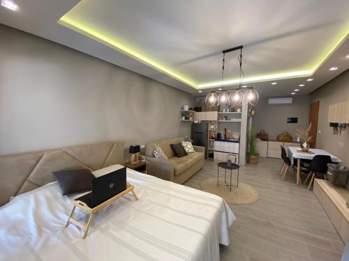 a living room with a couch and a laptop on a bed at Qerret Boutique Studio Apartment in Golem