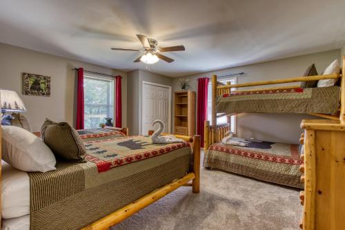 a bedroom with two bunk beds and a ceiling fan at Fun & Games by HoneyBearCabins 2BR/1BA Sleeps 7 in Sevierville