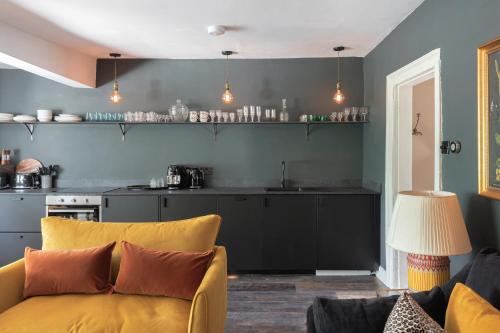 a living room with a yellow couch and a kitchen at Central Apartment With Private Parking in Bath