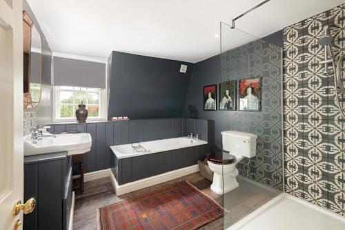 uma casa de banho com uma banheira, um lavatório e um WC. em Central Apartment With Private Parking em Bath