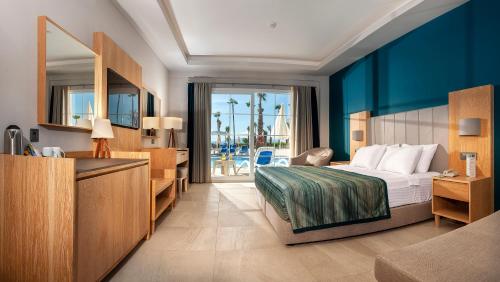 a hotel room with a bed and a view of the ocean at Ephesia Holiday Beach Club in Kuşadası