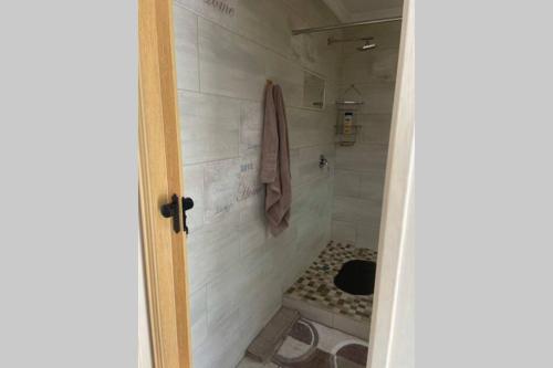 a bathroom with a shower with a tiled floor at Anju@Beach in Margate