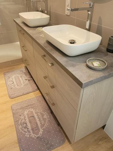 a bathroom with a sink and a bathroom rug at Villa repos in Neuilly-lʼHôpital