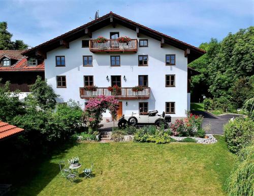 a large white house with a car in the yard at Kötzing am Golfplatz in Chieming