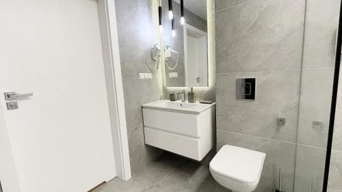 a bathroom with a white toilet and a sink at Morska Perła in Rogowo