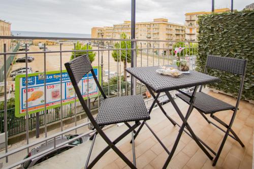 une table et deux chaises sur un balcon dans l'établissement SUITE ROMA, à Cefalù