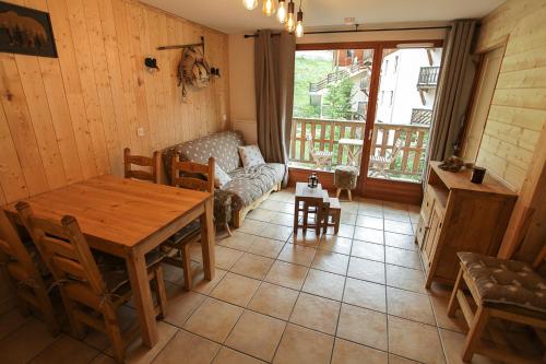 un salon avec une table en bois et un canapé dans l'établissement L'Alpin- Appartement 2ch au pied des pistes- tarif lits faits et linge de toilette compris, à Aussois