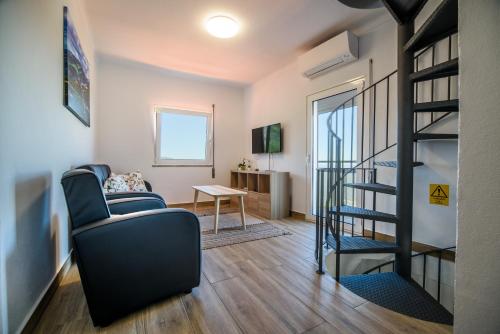 sala de estar con escalera y silla en Casa do Beco - Fabulous 3 Bedroom House with an Office, Seia, Serra da Estrela, 