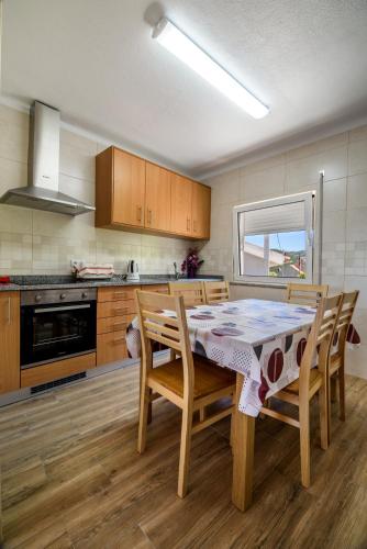 a kitchen with a table and chairs and a stove at Casa do Beco - Fabulous 3 Bedroom House with an Office, Seia, Serra da Estrela in Lapa dos Dinheiros