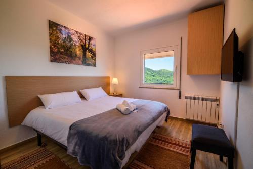 a bedroom with a large bed and a window at Casa do Beco - Fabulous 3 Bedroom House with an Office, Seia, Serra da Estrela in Lapa dos Dinheiros