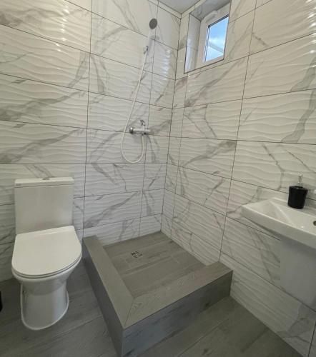 a white bathroom with a toilet and a sink at GRAFIT in Zatoka