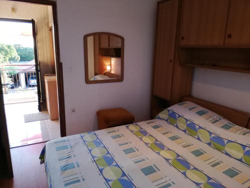 Dormitorio pequeño con cama y espejo en Apartment Stella, en Vodnjan