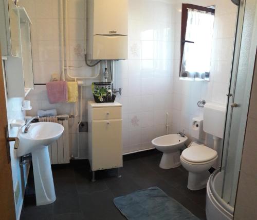 a white bathroom with a sink and a toilet at Apartment Stella in Vodnjan
