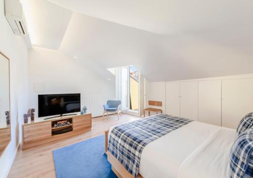 a bedroom with a bed and a flat screen tv at Mouzinho da Silveira Unique Apartments, by Oporto Collection in Porto