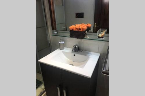 ein Bad mit einem Waschbecken und einem Korb mit Orangen in der Unterkunft Apartamento en la playa de Calafell. Barcelona in Calafell