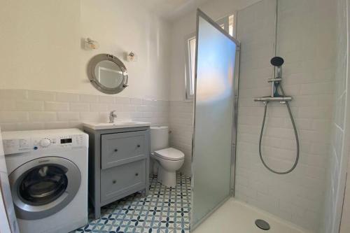 une salle de bain avec une machine à laver et un lave-linge dans l'établissement Maison de plage avec SPA/Jacuzzi à 250 m de la mer (la clé des chouans), à La Tranche-sur-Mer