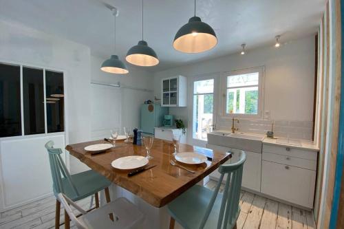 une cuisine avec une grande table et des chaises en bois dans l'établissement Maison de plage avec SPA/Jacuzzi à 250 m de la mer (la clé des chouans), à La Tranche-sur-Mer