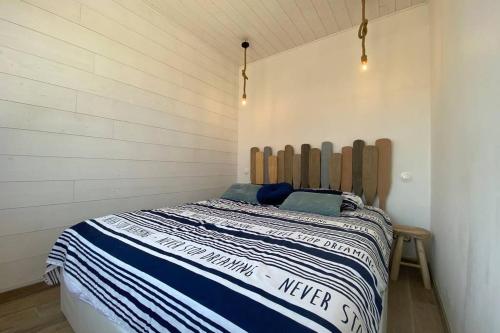 une chambre avec un lit avec une tête de lit en bois dans l'établissement Maison de plage avec SPA/Jacuzzi à 250 m de la mer (la clé des chouans), à La Tranche-sur-Mer