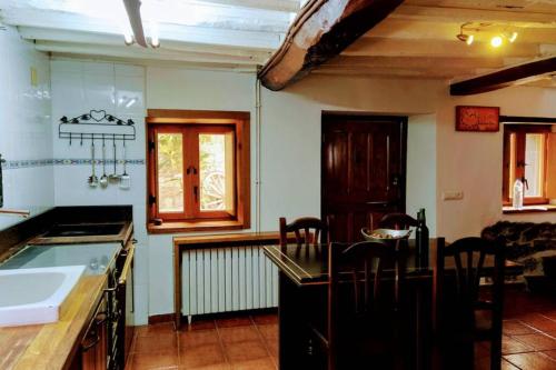 eine Küche mit einer Spüle und einer Arbeitsplatte in der Unterkunft Casa Ferreira, Senda del Oso in Oviedo