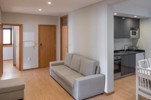 a living room with a couch and a kitchen at Apartamentos Portodouro - Ribeira in Porto