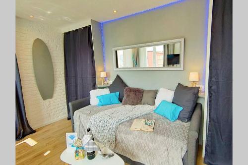 a bedroom with a bed and a mirror on the wall at KITESURF - 100M PLAGE - DECO DESIGN in Berck-sur-Mer