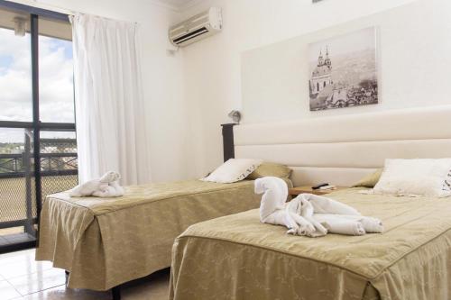 two beds in a room with towel animals on them at Hotel Casino Fortunata in Federación
