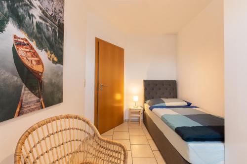 a small bedroom with a bed and a chair at Ferienwohnung Burgkirchen in Unterneukirchen