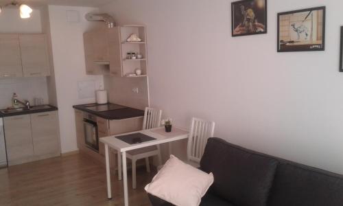 ein Wohnzimmer mit einem Tisch und einer Küche in der Unterkunft Apartament Ruczaj 2 in Lublin