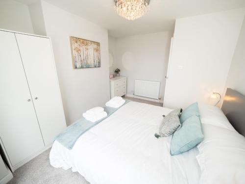 sypialnia z białym łóżkiem z niebieskimi poduszkami w obiekcie Sea View House w Scarborough