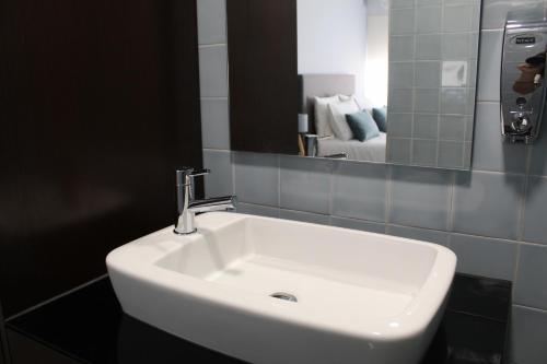 a white sink in a bathroom with a mirror at Alojarte in Figueiros