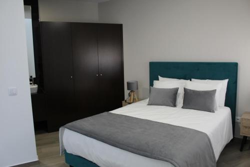 a bedroom with a large bed with a green headboard at Alojarte in Figueiros