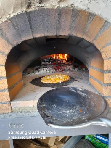 a pizza is cooking in a brick oven at Chambres 2 caps in Ambleteuse