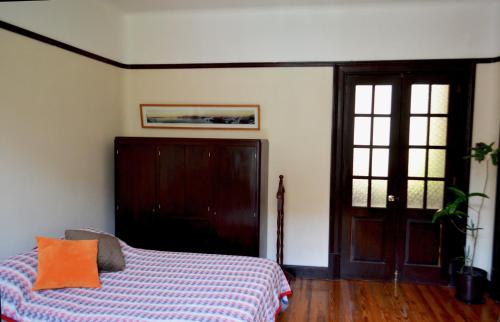 a bedroom with a bed with an orange pillow on it at Bonita habitación en departamento compartido a dos calles del Zócalo CDMX in Mexico City