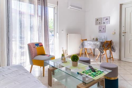 een woonkamer met een glazen tafel en stoelen bij Grigo apartments in Alexandroupoli