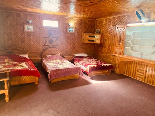 a room with two beds and a tv in it at Taimoor Hotel swat Kalam in Kalām