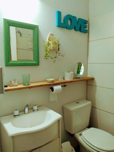 a bathroom with a sink and a toilet and a mirror at El Trotamundos in Puerto Pirámides