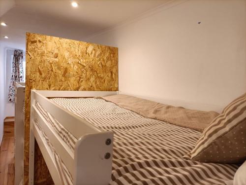 a bed in a room with a wall at NOW Bastidor Jovial in Lisbon
