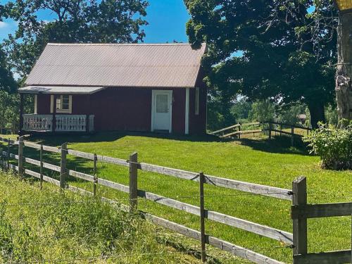 een klein huis met een hek ervoor bij 4 person holiday home in VETLANDA in Vetlanda