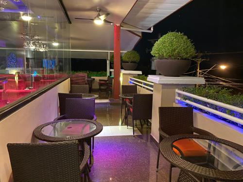 a patio with chairs and a table with purple lights at Grand Diamond Hotel Trinidad in Piarco