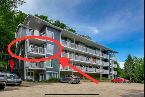 a building with two cars parked in front of it at Le PanoramiK by Gestion ELITE in Mont-Tremblant