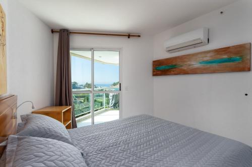 um quarto com uma cama e vista para o oceano em Flat na Praia do Pontal com vista deslumbrante - Villa del Sol Residences no Rio de Janeiro