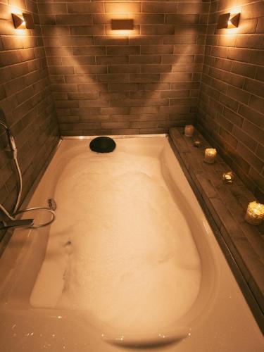 a large bath tub in a bathroom with a shower at Hotel Romeo in Korçë