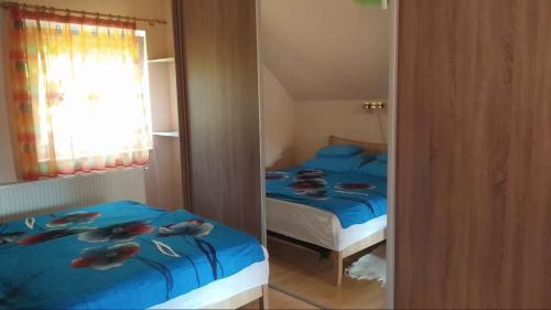 Un dormitorio con una cama con sábanas azules y un espejo. en Apartment in Balatonmariafürdo 19297, en Balatonmáriafürdő