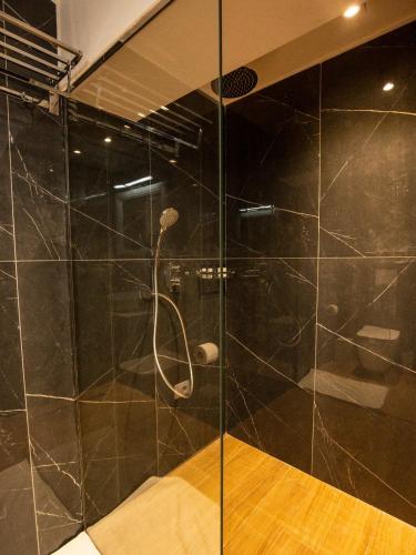 a bathroom with a shower with a glass door at Hotel Romeo in Korçë