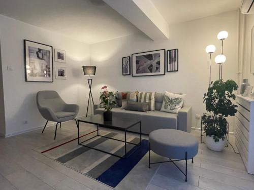 a living room with a couch and a table and chairs at Apartment Central in Bajina Bašta