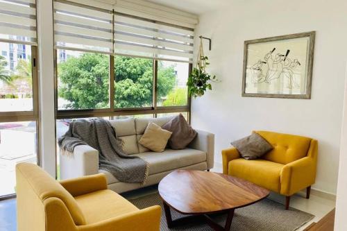 a living room with a couch and two chairs and a table at Apartamento Cleo in Cancún