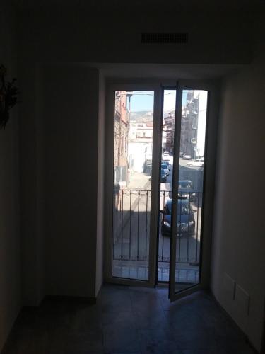 Habitación vacía con puerta a un balcón en Casa Graziella, en SantʼAgata di Militello