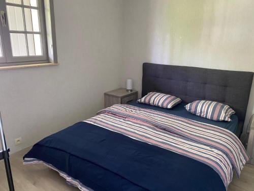 een slaapkamer met een blauw bed met 2 kussens bij Beau Sejour in Heuvelland